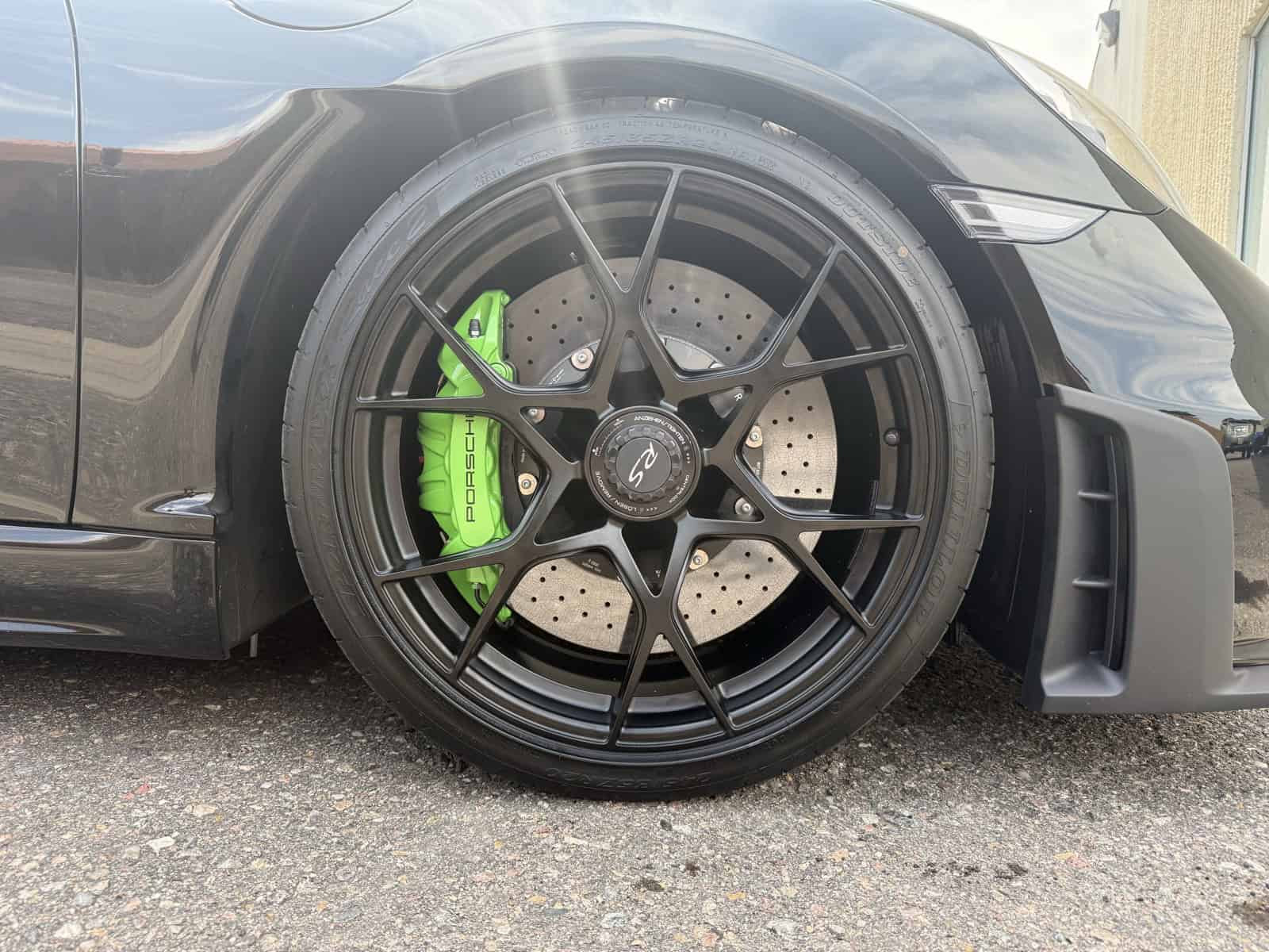 Porsche green powder coated brake calipers behind black mesh wheels by ColorWerks Denver