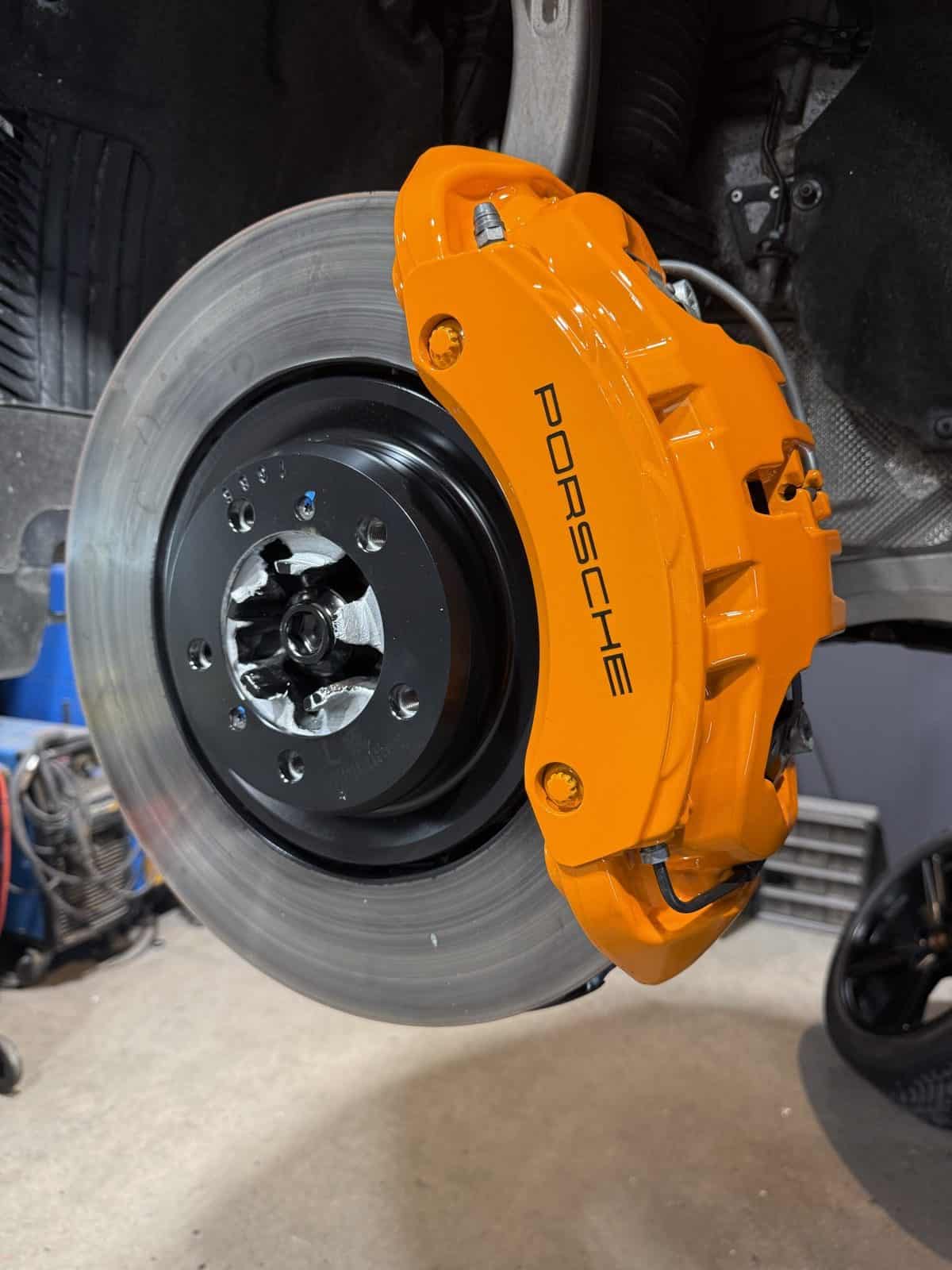 Porsche brake caliper after powder coating - orange finish by ColorWerks Denver