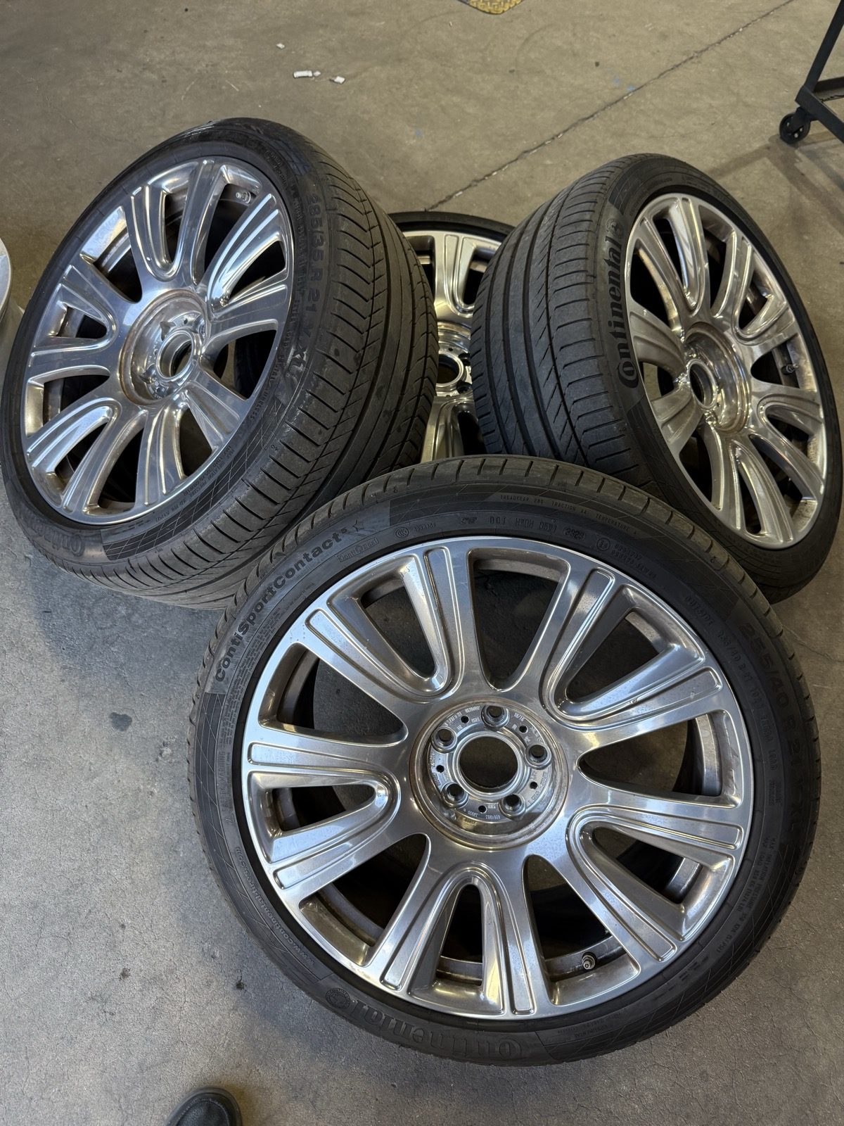 Before: four chrome wheels on tires stacked in the shop, waiting for stripping and powder coat