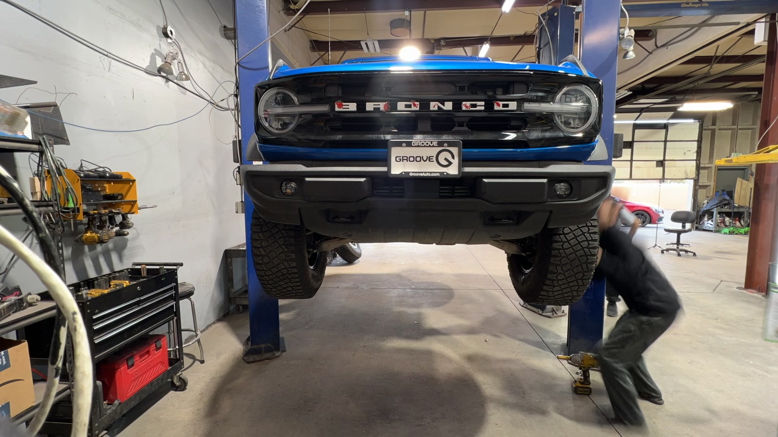 Ford Bronco on the lift with front wheels off for powder coating