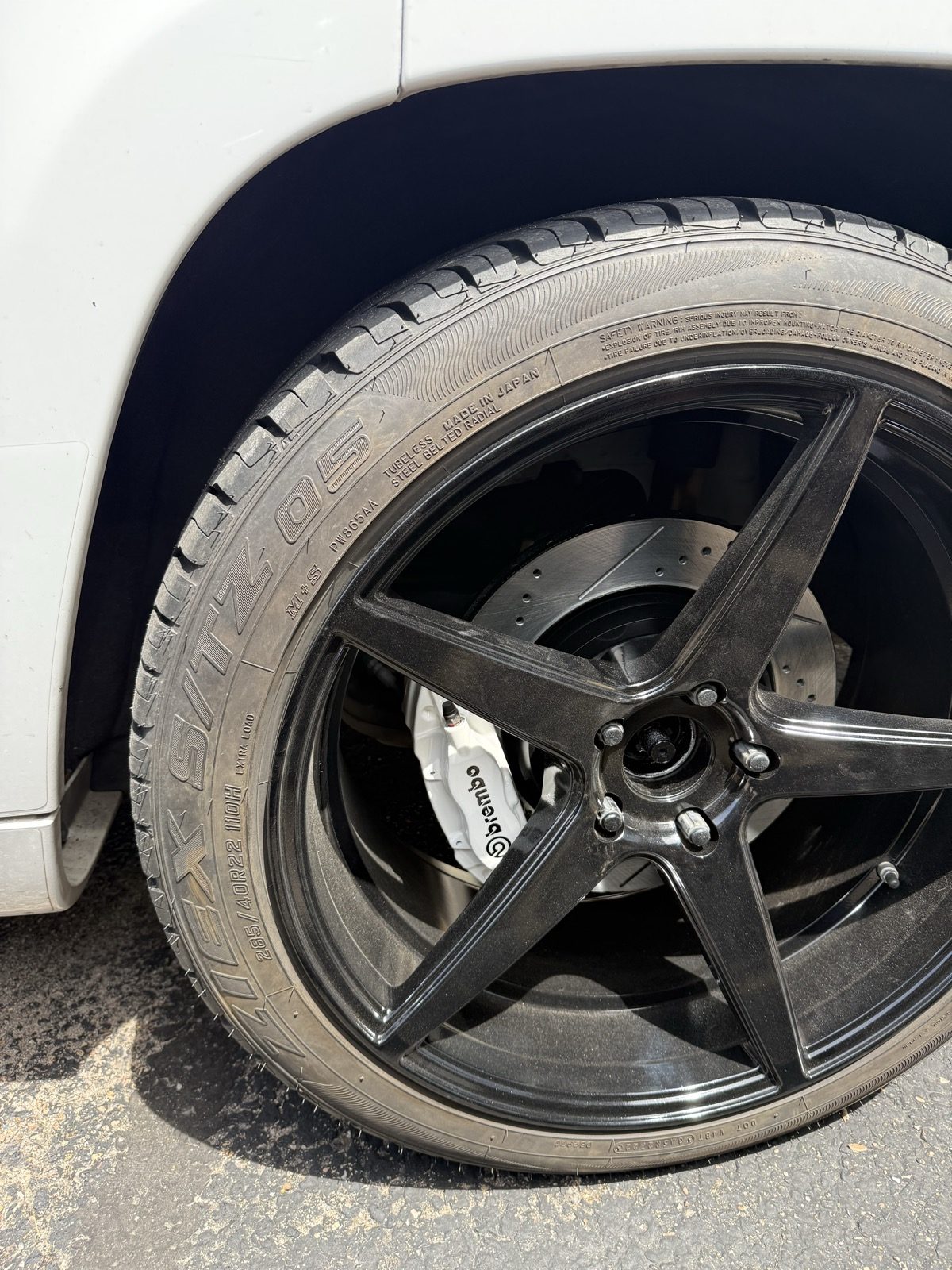 Gloss black powder coated wheel with a white painted brake caliper behind it